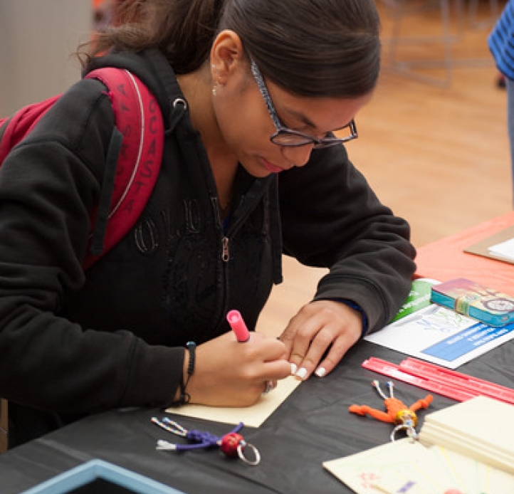 Student participating at the event, while writing on paper