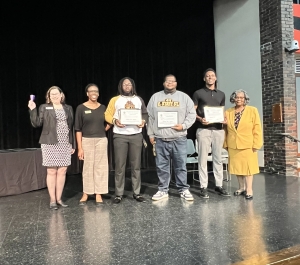 A group of people standing on stage with awards