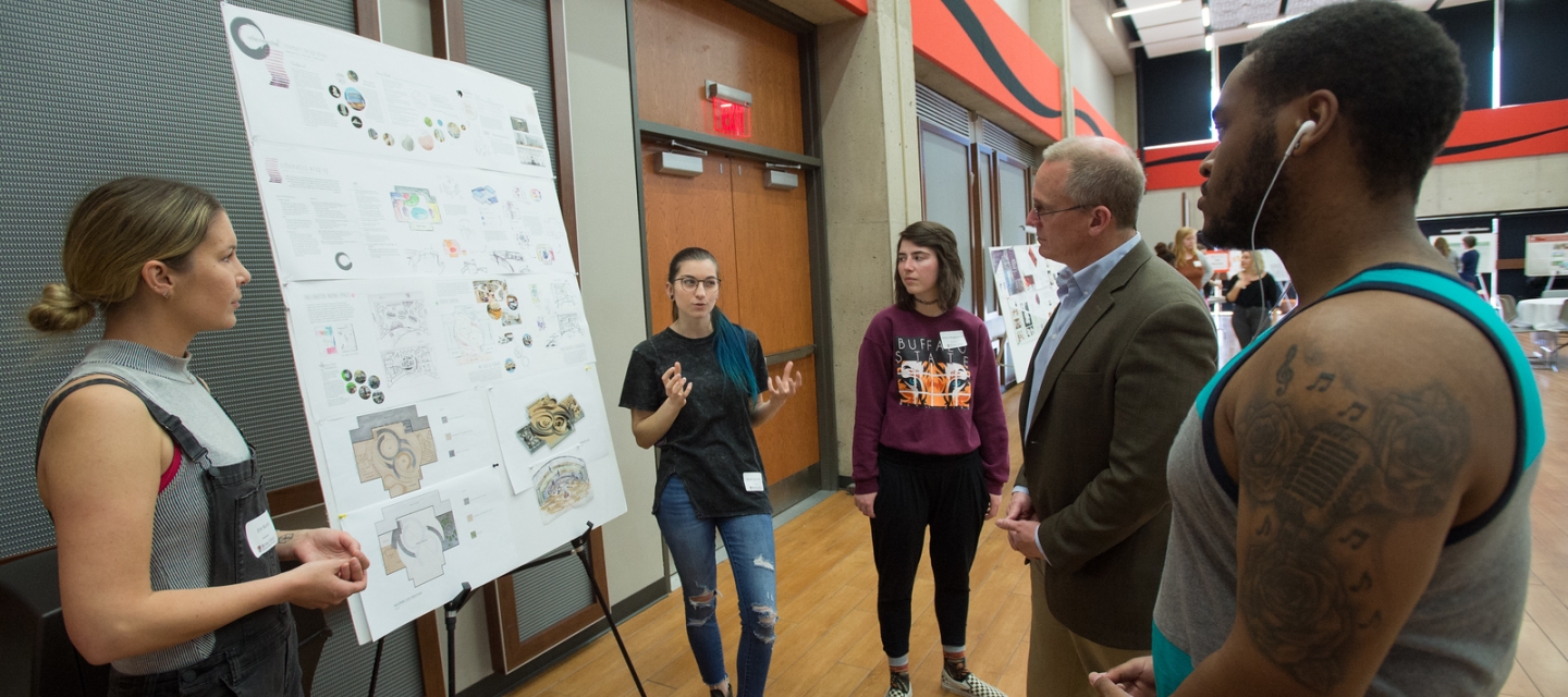 Students and faculty review research presentation